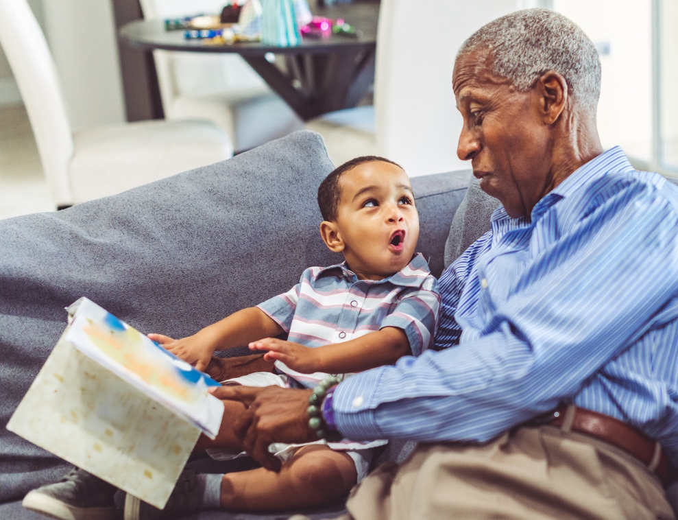 Grandchild and grandfather reading