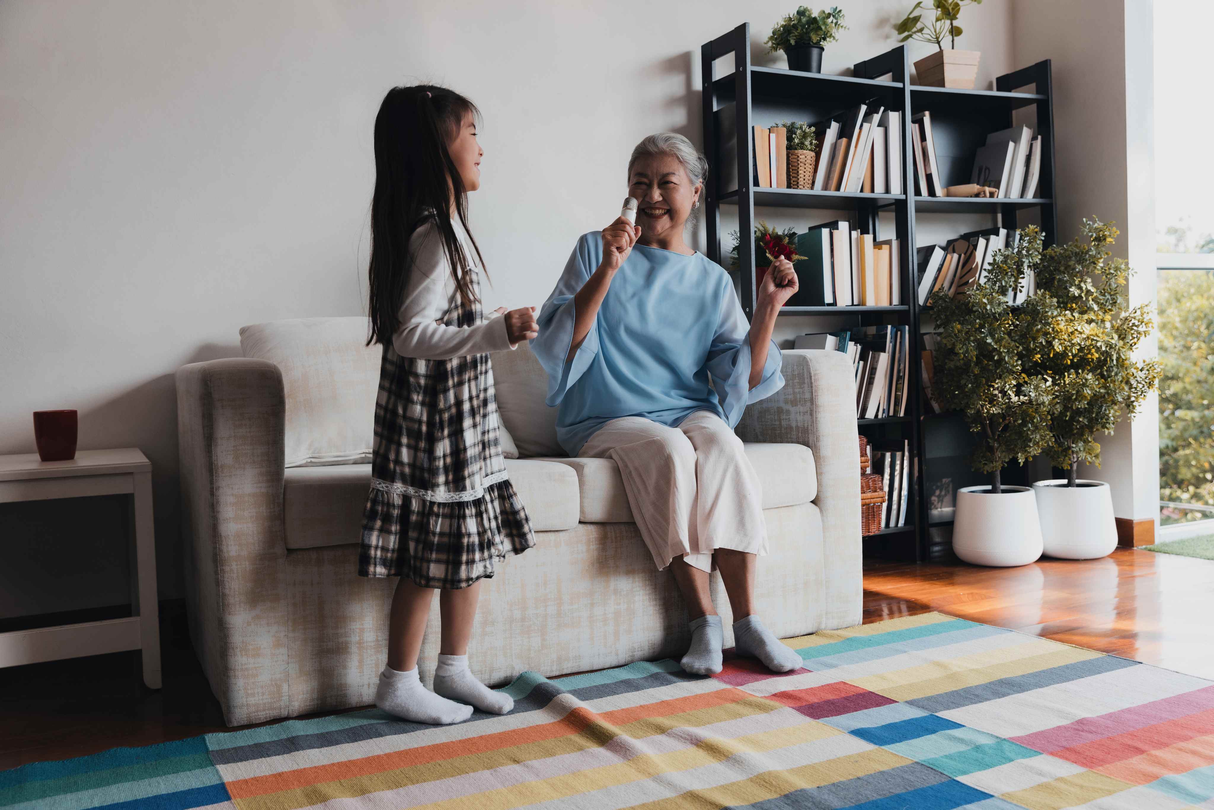 grandmother and granddaughter enjoying ice cream together in living room