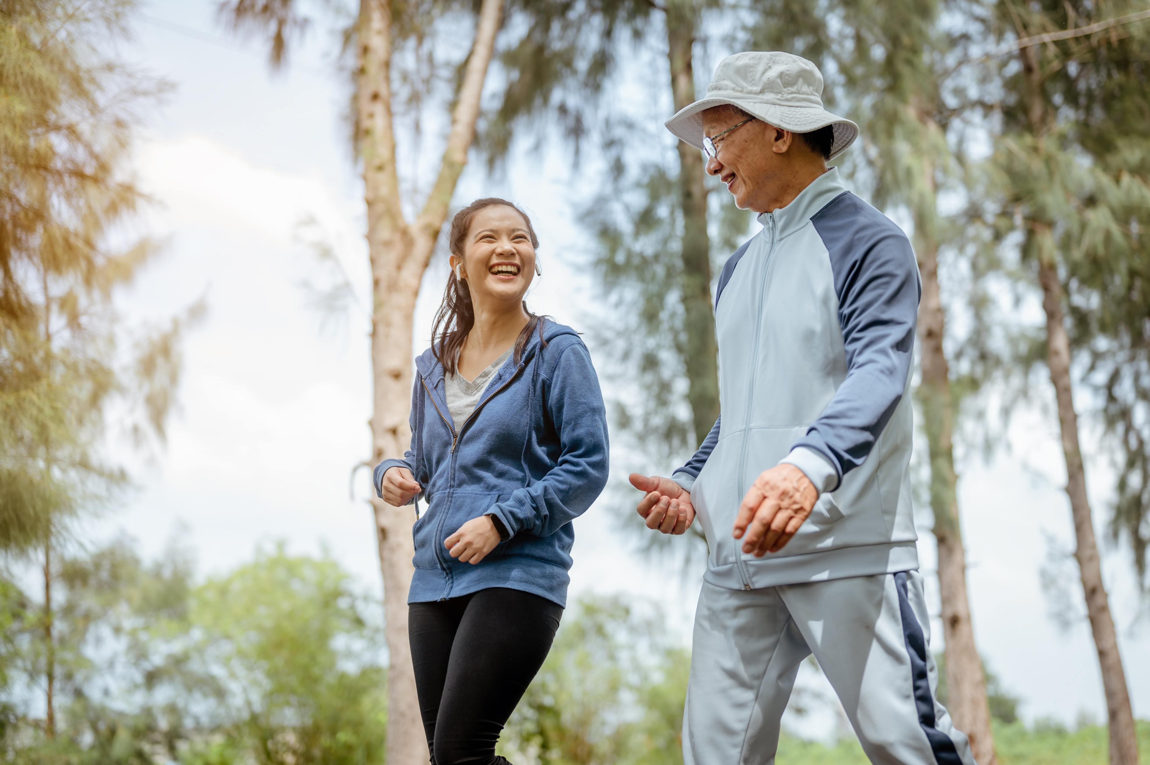 Happy couple jogging together outdoors in park wearing athletic clothing