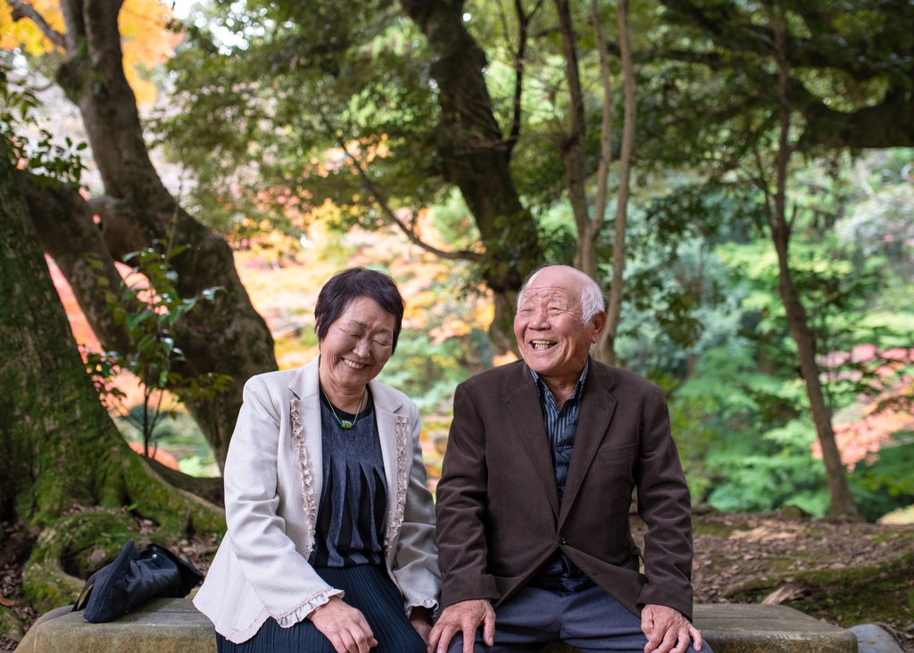 Happy senior couple resting in forest