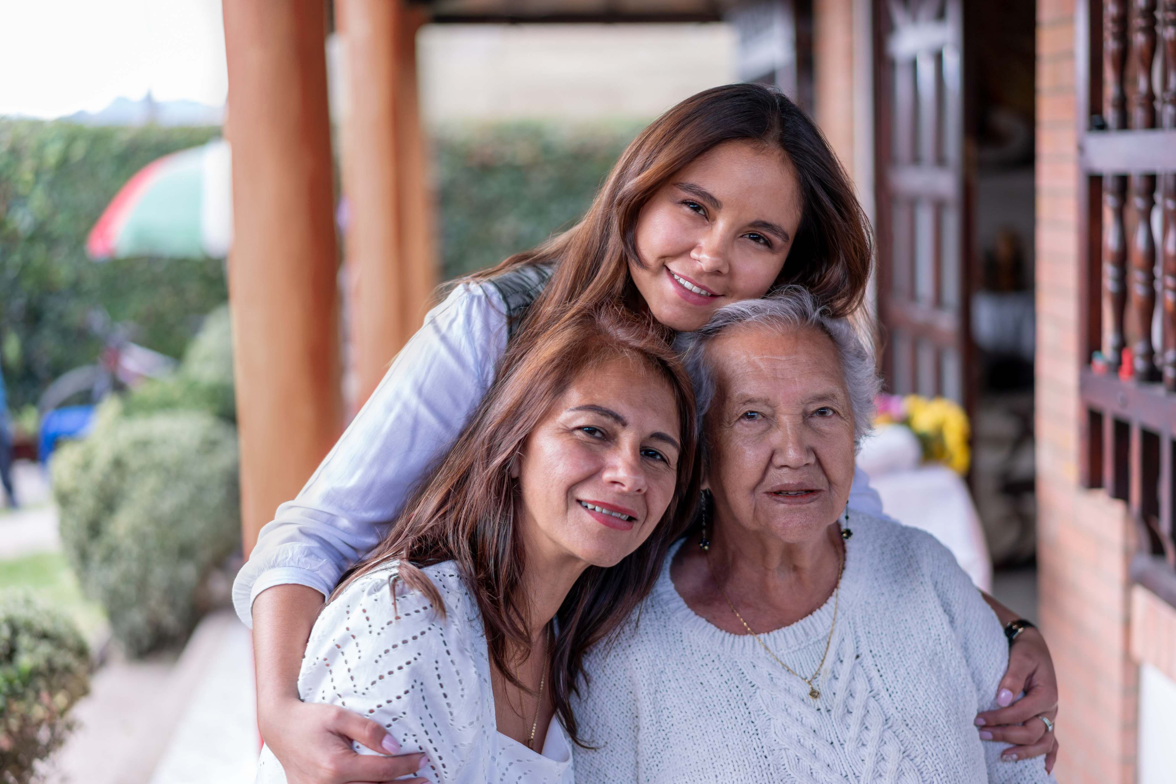 Three generations of women smiling together outdoors